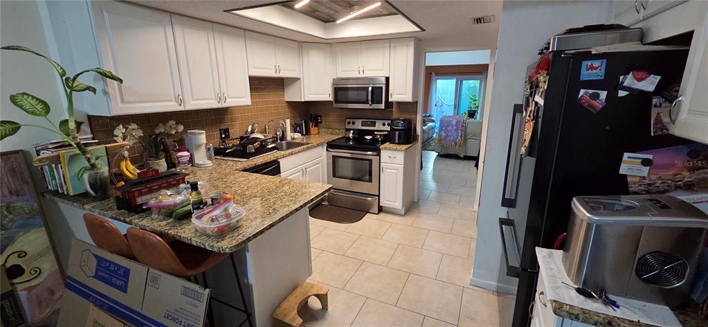 165 Pine Cone Trail Ormond Beach, FL 32174 - Photo 11 of 25 a kitchen with a stove and a refrigerator