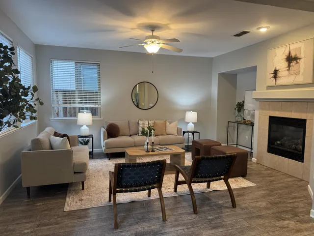 a living room with furniture a fireplace and a chandelier