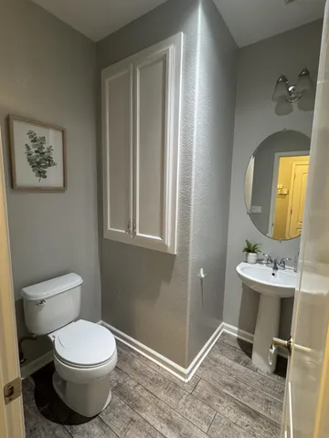 a bathroom with a toilet sink and mirror