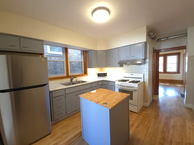 a kitchen with a refrigerator a stove top oven and a sink