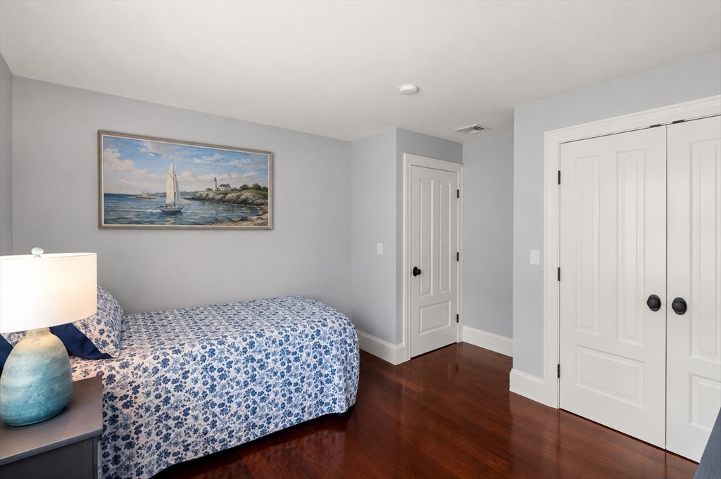 29 Maple Lane, Unit 29 Medfield, MA 02052 - Photo 24 of 42 a bedroom with a bed and wooden floor