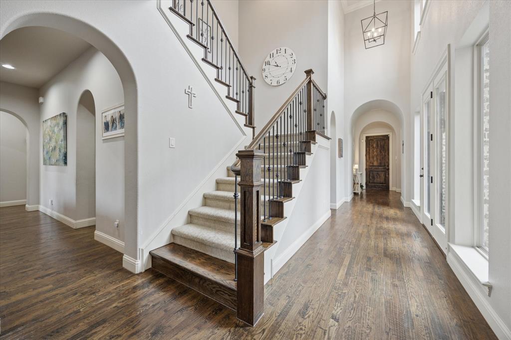 580 Butchart Drive Prosper, TX 75078 - Photo 12 of 40 Foyer featuring dark wood finished floors, baseboards, stairs, arched walkways, and a high ceiling