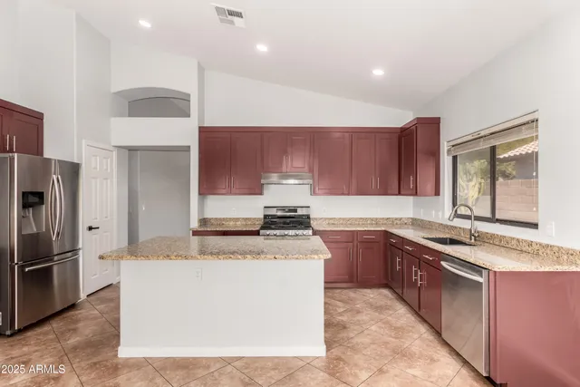 a kitchen with stainless steel appliances granite countertop a stove a sink dishwasher a refrigerator and a oven