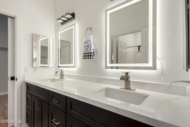 a bathroom with double vanity sinks and a mirror