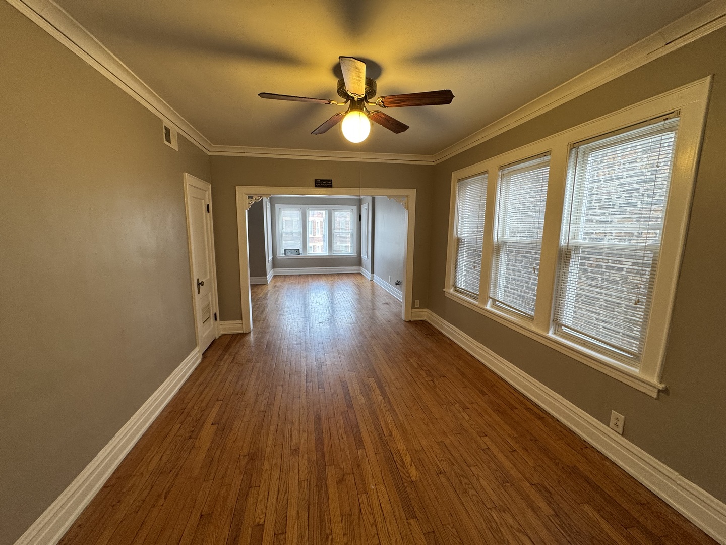 6840 South Champlain Avenue, Unit 2 Chicago, IL 60637 - Photo 4 of 12 a view of empty room with wooden floor and fan