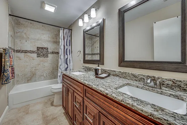 a bathroom with a granite countertop tub sink and mirror