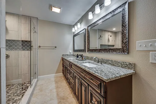 a bathroom with a granite countertop sink and a mirror
