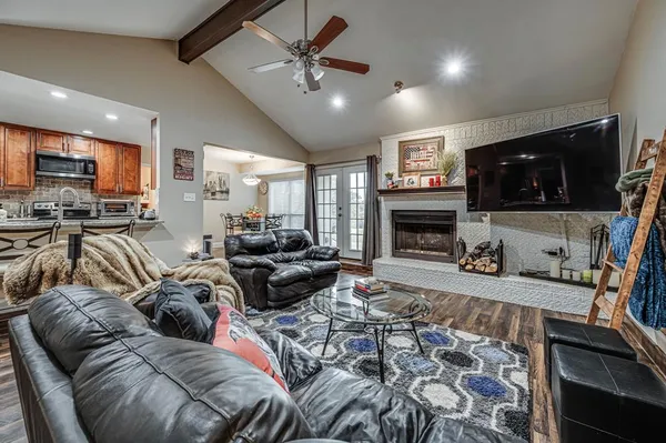 a living room with furniture a flat screen tv and a fireplace