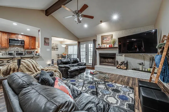 a living room with furniture a flat screen tv and a fireplace