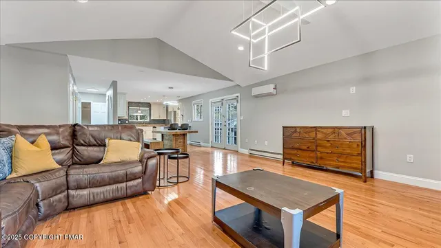 a kitchen with a stove a refrigerator a sink dishwasher with a dining table and chairs with wooden floor