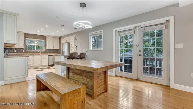 a living room with furniture kitchen view and a wooden floor