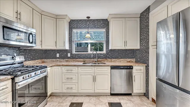 a kitchen with stainless steel appliances granite countertop a sink and cabinets