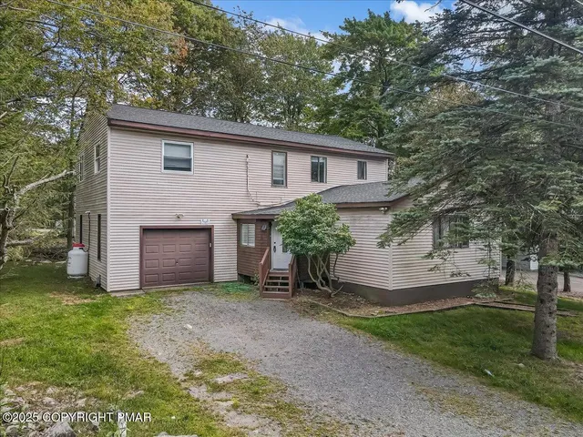 a view of a yard in front of a house with large tree
