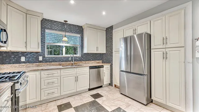 a kitchen with granite countertop white cabinets and a stove