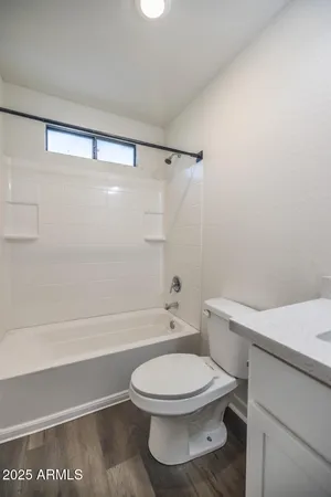 a white toilet and tub sitting next to a bathroom sink