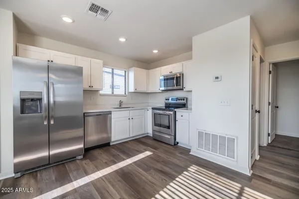 a kitchen with a refrigerator a sink and cabinets