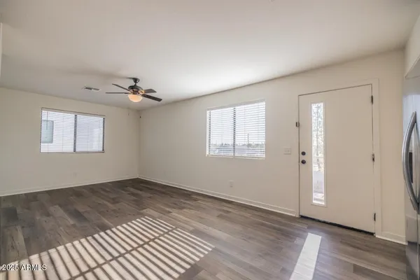 a view of an empty room with wooden floor and a window