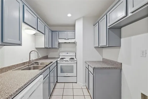 a kitchen with stainless steel appliances granite countertop a sink stove refrigerator and cabinets