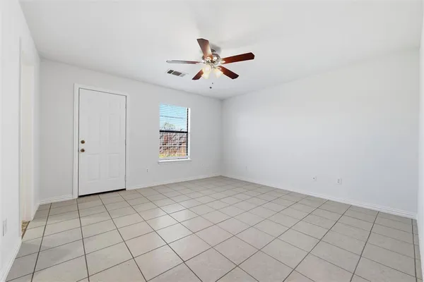 an empty room with windows and fan