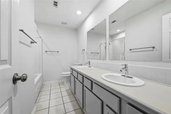 a bathroom with a sink a toilet a mirror and shower