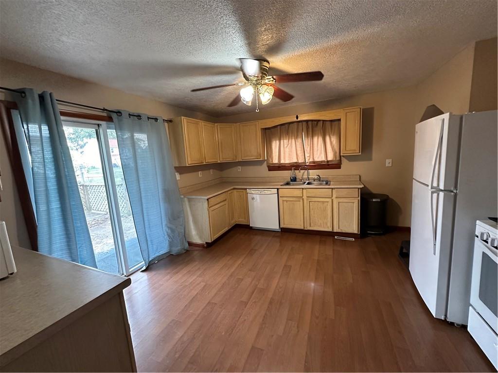 40 2nd Street Lawrence, PA 15055 - Photo 7 of 15 a kitchen with stainless steel appliances granite countertop a refrigerator a sink dishwasher a stove and white countertops with wooden floor