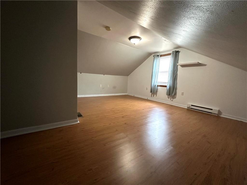 40 2nd Street Lawrence, PA 15055 - Photo 10 of 15 an empty room with wooden floor and windows with curtains