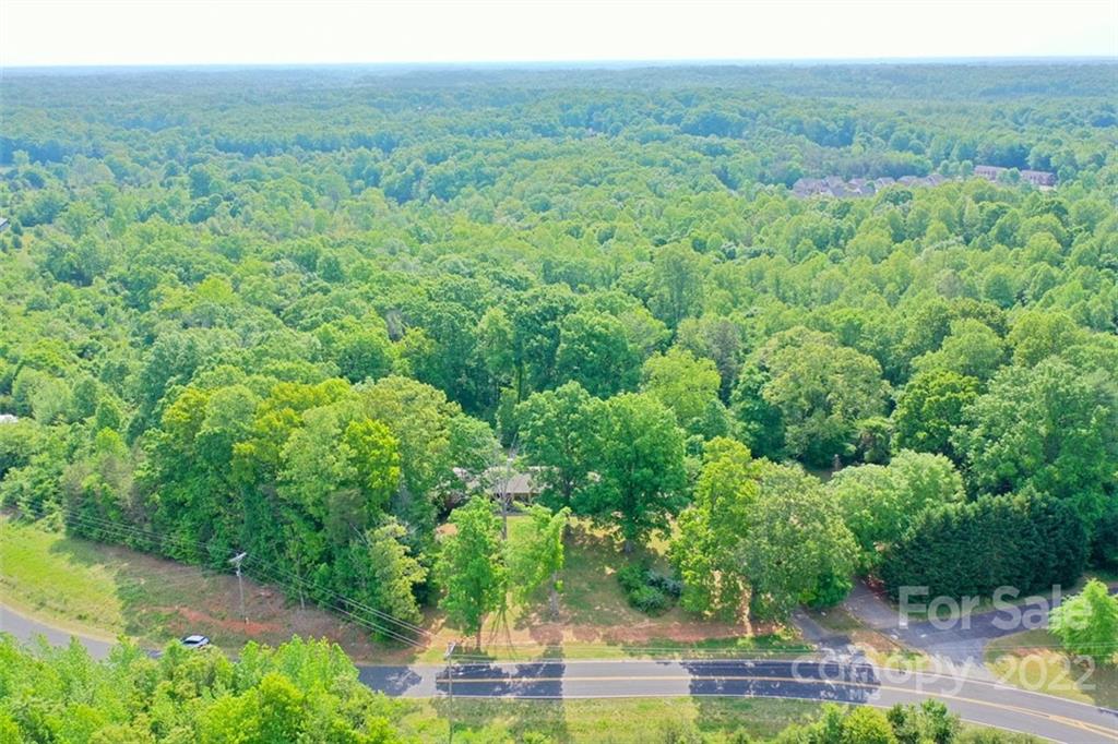 142 Koontz Road Mocksville, NC 27028 - Photo 42 of 47 a view of a lush green forest with trees and some houses