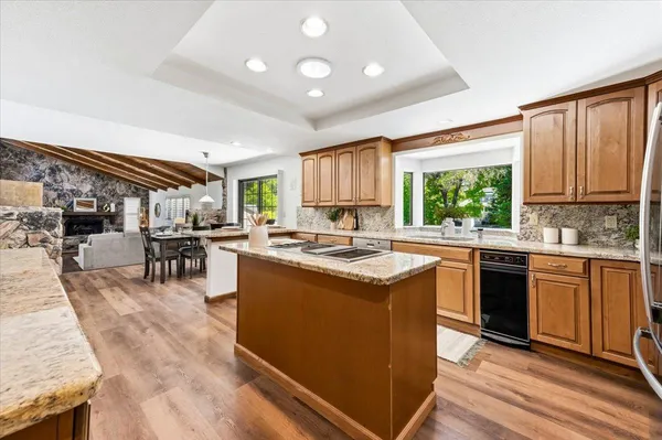 a kitchen with stainless steel appliances granite countertop sink stove top oven and cabinets
