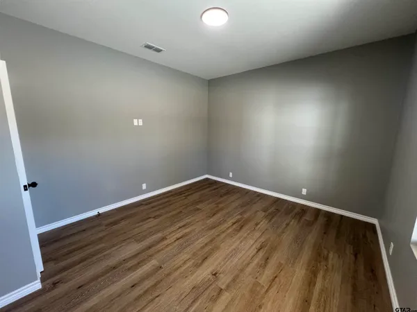 a view of room with wooden floor and fan