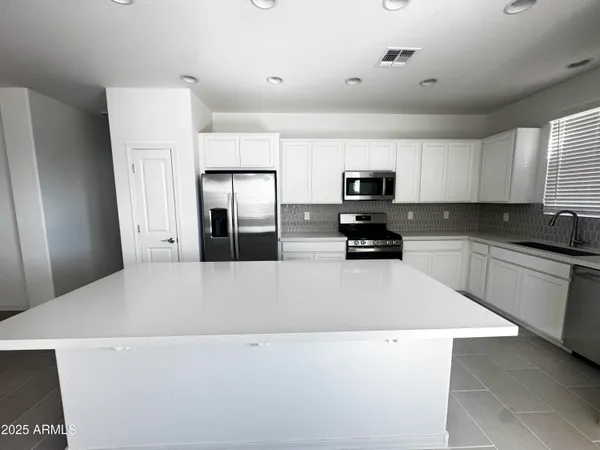 a kitchen with a refrigerator and a stove top oven