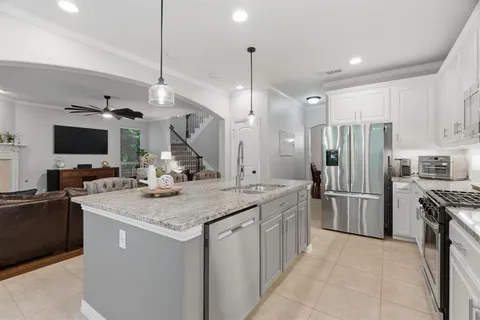 a kitchen with stainless steel appliances granite countertop a sink refrigerator and microwave