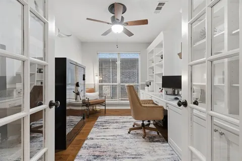 a view of a workspace with furniture and a window