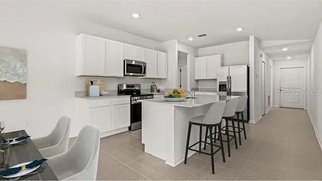a kitchen with kitchen island white cabinets and stainless steel appliances