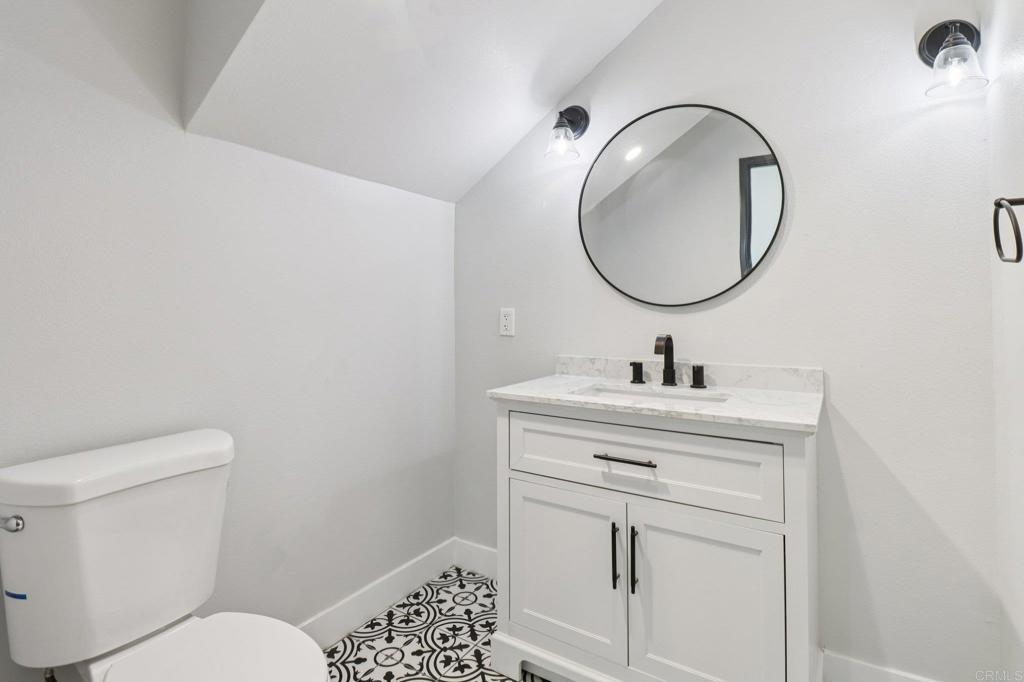 139-41 Almond Street Fallbrook, CA 92028 - Photo 14 of 35 a bathroom with a toilet a sink and mirror