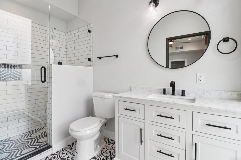 139-41 Almond Street Fallbrook, CA 92028 - Photo 5 of 35 a bathroom with a toilet sink vanity and mirror