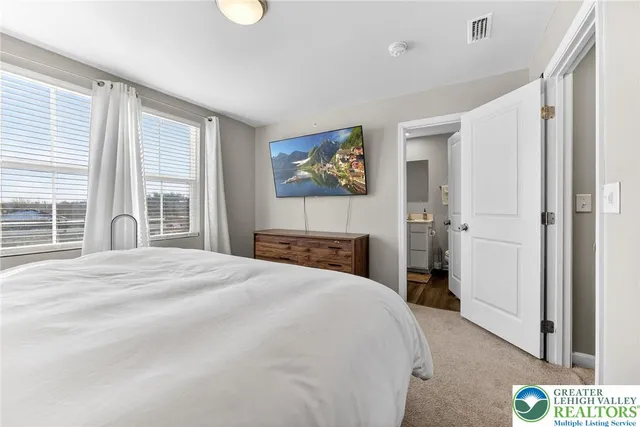 a bedroom with a bed and a painting on the wall