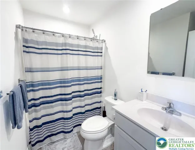 a bathroom with a sink a toilet and a mirror