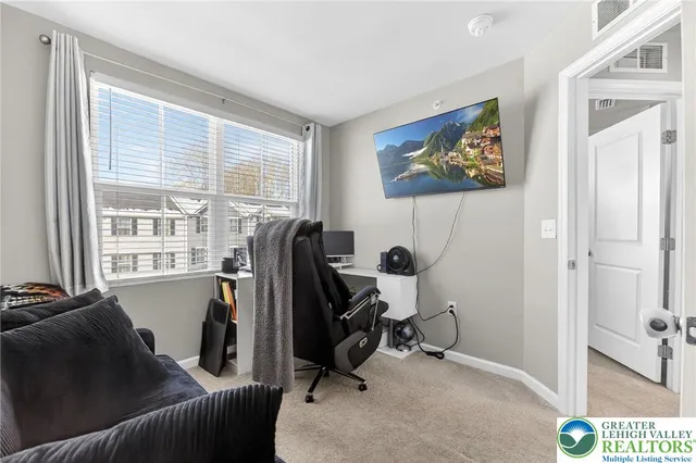 a view of a workspace with furniture and a window