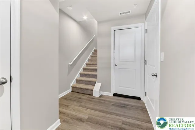 a view of a hallway with wooden floor and staircase