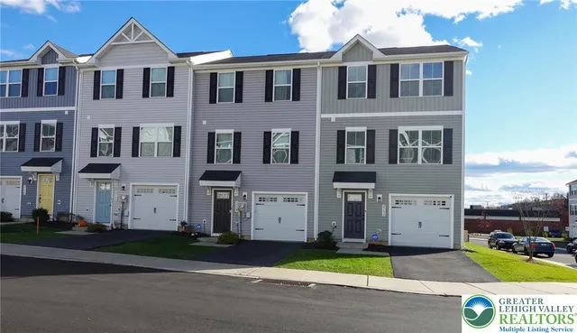 a view of a white house with a yard and table in front of it