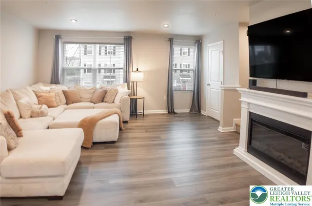 a living room with furniture a flat screen tv and a fireplace