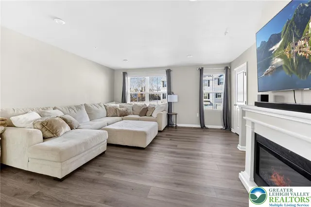 a living room with furniture a fireplace and a flat screen tv