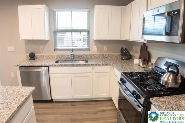a kitchen with a sink stove top oven and cabinets