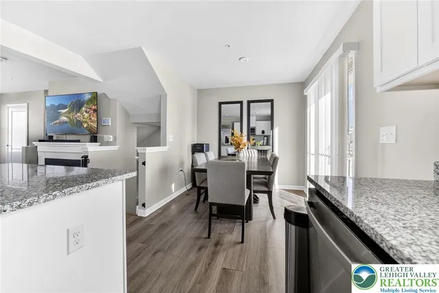 a kitchen with granite countertop kitchen island a stove a sink a dining table and chairs