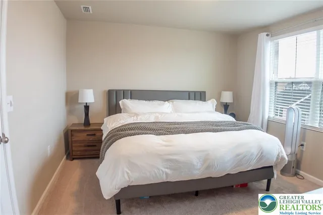 a large bed sitting in a bedroom next to a window