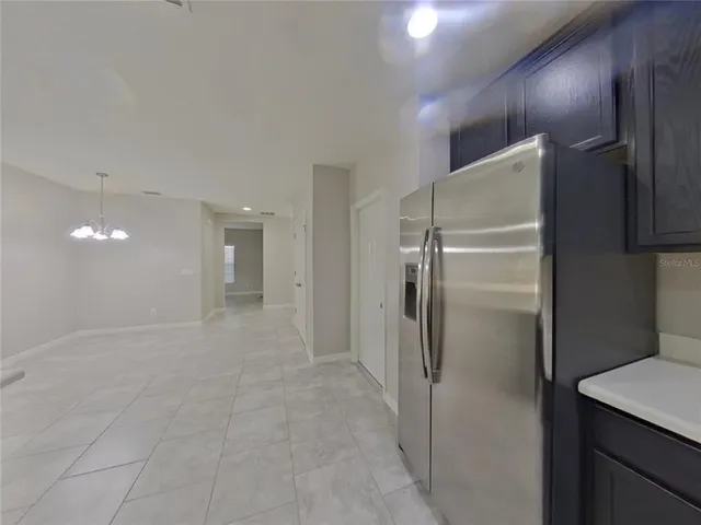 a view of a refrigerator in kitchen and wooden cabinets