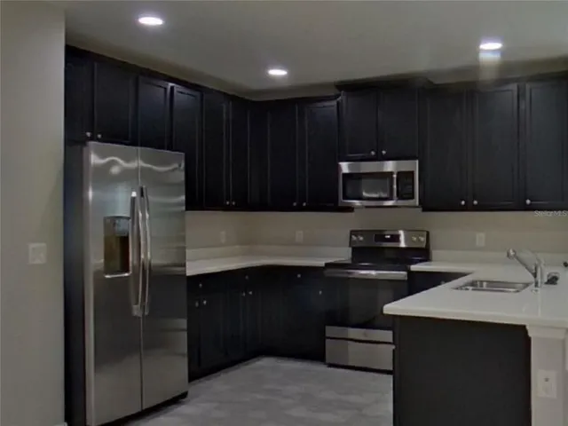 a kitchen with wooden cabinets and stainless steel appliances