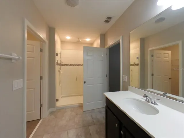 a bathroom with a double vanity sink a mirror and a shower