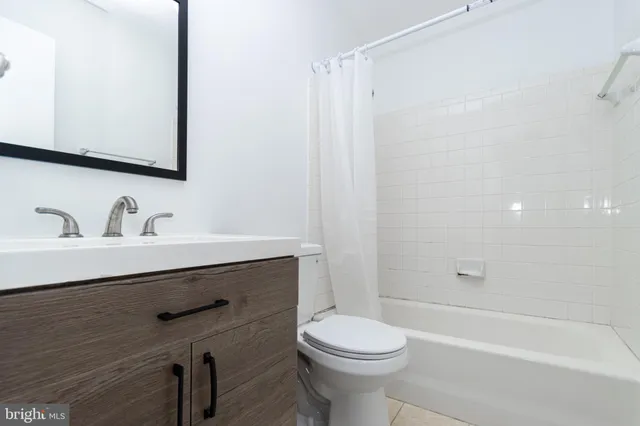 a bathroom with a sink a toilet a mirror and shower