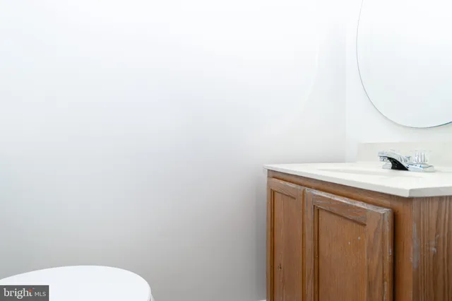 a bathroom with a granite countertop sink and a toilet